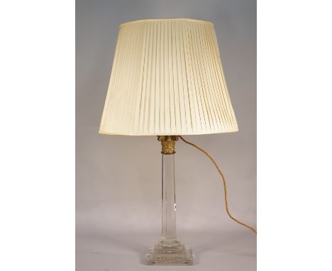 A modern perspex and gilt metal mounted table lamp of Corinthian column form, with a pleated cream shade, 77cm high overall. 