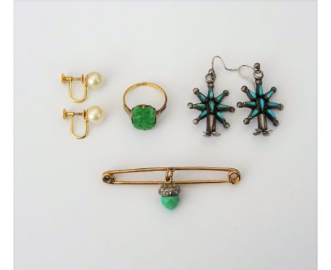 A gold ring mounted with a cut cornered rectangular jade, having carved and pierced decoration, detailed 9CT, ring size N, a 