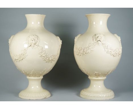 A near pair of large Wedgwood creamware baluster vases, circa 1767, each bulbous body applied with four lion masks suspending