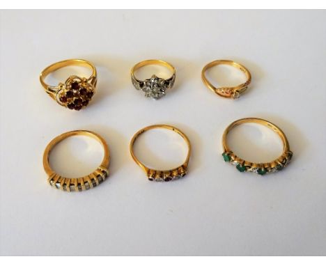 A gold and diamond set nine stone cluster ring, a gold and diamond set half hoop ring, detailed 10 K, a 9ct gold, emerald and