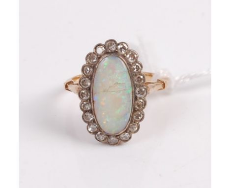 An early 20th century yellow metal opal and diamond set dress ring, the cabochon opal (cracked) within a surround of 20 small