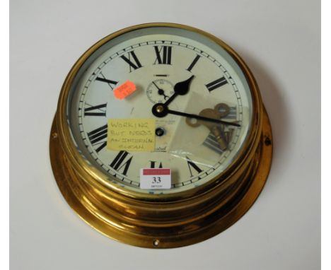 A Sestrel brass cased ships bulkhead clock having a circular enamel dial with Arabic numerals and a subsidiary seconds dial, 