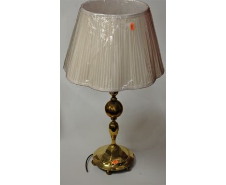 A large turned brass table lamp having a pleated silk shade, height 70cm