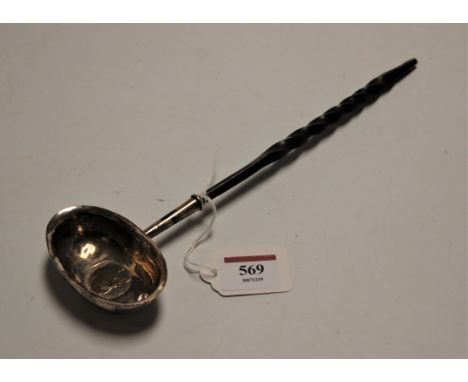 A George III white metal toddy ladle, inset with a 1787 sixpence, on a turned whalebone handle