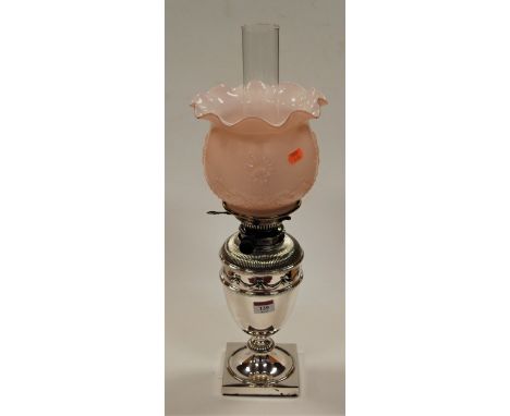 A 20th century oil lamp, having pink opalescent frilled glass shade, the silver plated base in the form of an urn with swag a