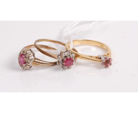 A 9ct gold, ruby and diamond cluster ring; together with a smaller 9ct gold, ruby and diamond cluster ring; and an 18ct gold 