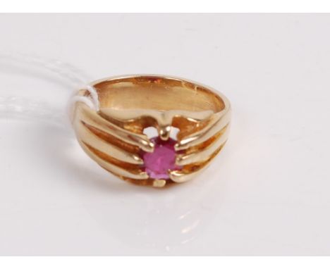 A yellow metal ruby set ring, the round cut ruby in an eight claw setting with reeded shoulders, unmarked but tests as 9ct, 4
