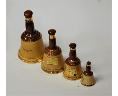 A Wade Bells Scotch Whisky bell together with three others (lacking contents)