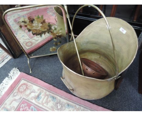 A large brass coal helmet, poker and mirror and brass fire screen