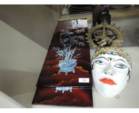 Two lacquered inlaid oriental plaques, mask, brass deity model and ethnic carving