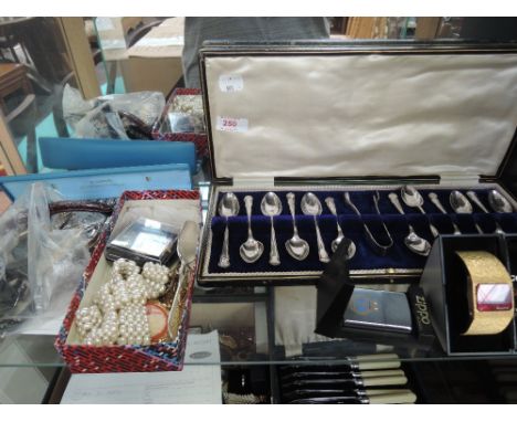 A shelf of costume jewellery including Accurist watch, box of spoons and sugar nips, zippo lighter etc