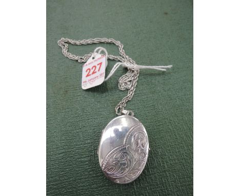 An HM silver locket having engraved decoration to front on a white metal rope chain stamped sterling