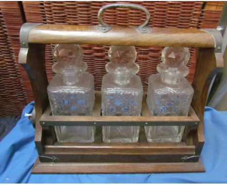 An oak and electroplated mounted three decanter tantalus