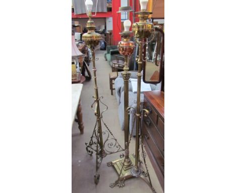 A telescopic brass standard lamp with oil reservoir converted to electricity, with a scrolling base together with two other s