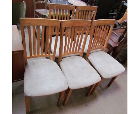 A set of six stick back dining chairs with upholstered seats together with a rectangular kitchen table