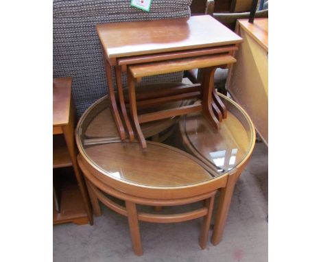 A light teak coffee table with a glass top and a set of three pointed oval occasional tables, together with a teak nest of th