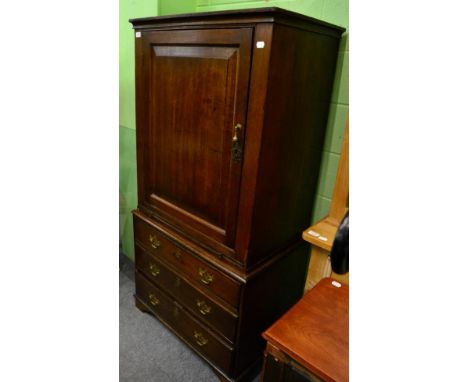 A George III oak cupboard on associated chest, the upper section with single door opening to reveal shelves, above a dressing