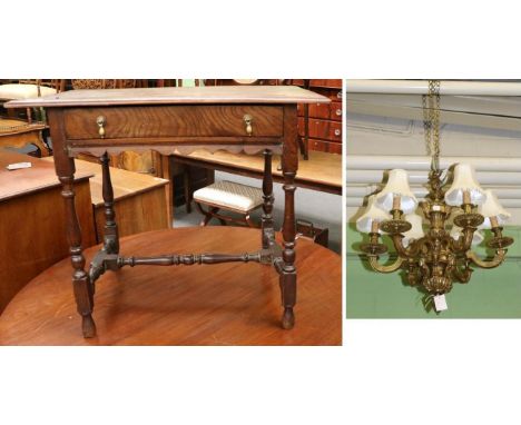 An 18th century oak side table and a brass six light chandelier Evidence of old worm. Top with splits forming. With pine draw