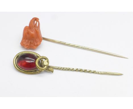 A yellow metal and coral stick pin and one other with red cabochon stone 