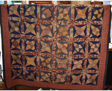 Quilt - This quilt comprises kite shapes within a four pointed star with the points facing into the corners of another seven 