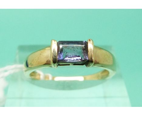 A 9ct gold ring set with an emerald cut amethyst (Size N)