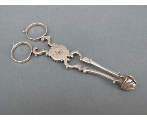 A pair of Georgian silver sugar tongs or nips, marked on each half with the lion passant together with a coin based ladle bow