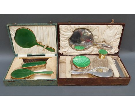 A cased hallmarked silver dressing table set comprising mirror and two brushes together with a green guilloche enamel dressin