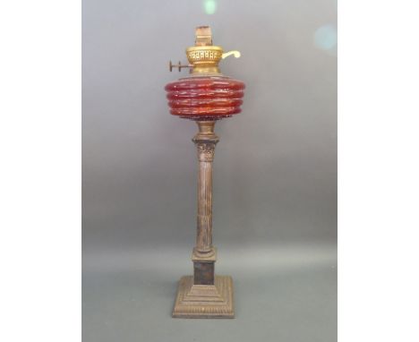 A silver plated Corinthian column oil lamp with red glass reservoir, height 57cm 