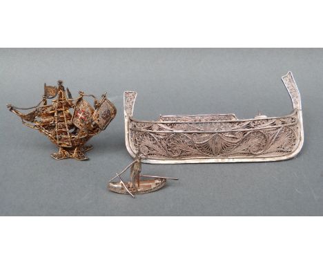 A silver filigree model of a boat, marked 917, possibly Maltese, 9.5cm long, a small silver filigree charm in the form of a b