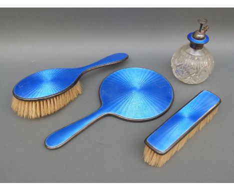 A George V guilloche enamel and hallmarked silver dressing table set comprising hand mirror, two brushes and an atomiser, mir