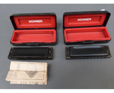 A cased Hohner 'Pro-Harp' harmonica in key of A together with a further example in C