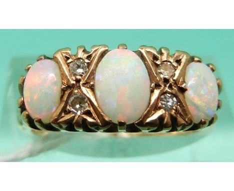 A 9ct gold ring set with three oval opal cabochons and four diamonds (Size L)