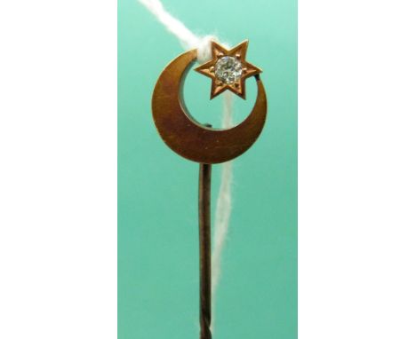 A yellow metal stick pin marked 15ct gold in the form of a crescent and star set with an old cut diamond