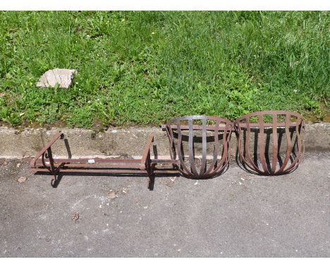 A pair of hay racks and a wall-mounted holder for a trough