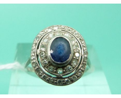 An Art Deco platinum ring set with a sapphire surrounded by two rows of diamonds (Size L)