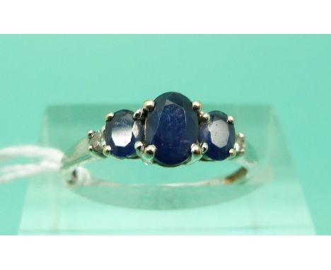 An 18ct white gold ring set with three oval sapphires and two diamonds (Size J)
