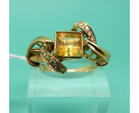 An 18ct gold ring set with a square step cut citrine and diamonds in a twist setting (Size R)