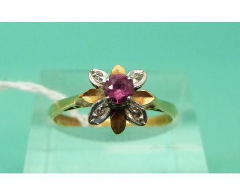 An 18ct gold ring set with a ruby and diamonds in a flower setting (Size O)
