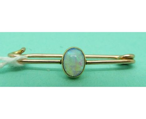 A gold brooch set with an opal cabochon