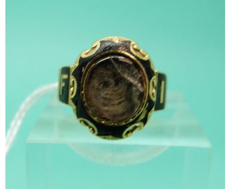 An 18ct gold mourning ring, London 1875, set with black enamel, "In Memory Of" to the outside of the band and a glass compart