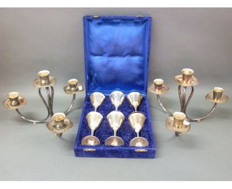 A pair of retro Danish or similar silver plated candelabra and a boxed set of six silver plated wine glasses