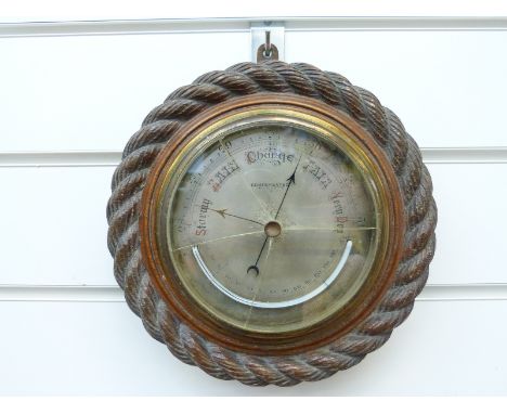 An oak aneroid barometer with curved thermometer below, 13cm dial