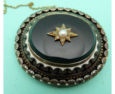 A Victorian mourning brooch set with black onyx, seed pearl and diamonds within an enamel border, verso a glass compartment f