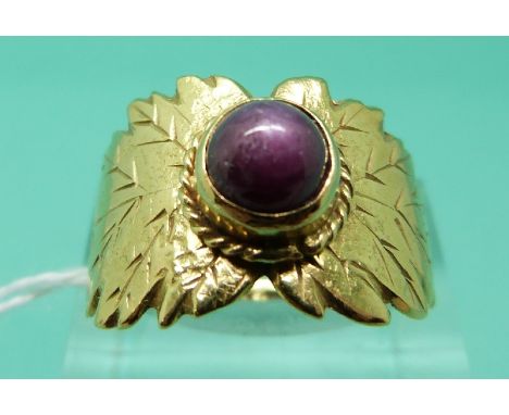 An 18ct gold ring set with a ruby cabochon showing asterism with leaf decoration (Size O)