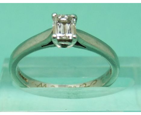 A platinum ring set with an emerald cut diamond measuring 0.35ct in original box from Beaverbrooks (size K)