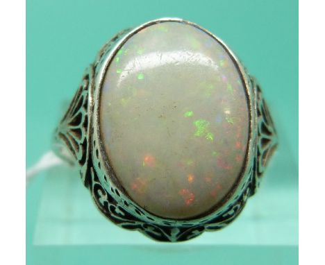 A white metal ring set with a large oval opal cabochon (Size K)