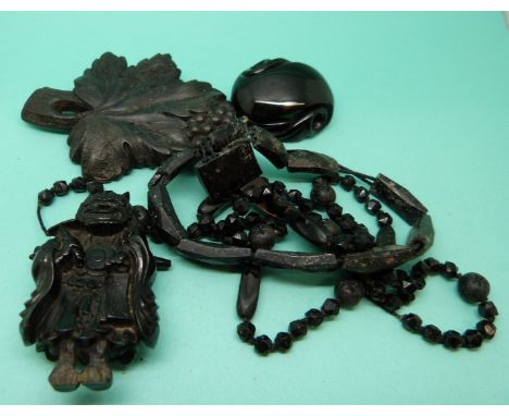 A jet netsuke in the form of a Japanese creature and three other pieces of Victorian jet