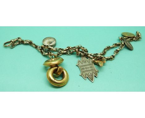A Victorian bracelet made up of faceted links with charms including a compass and a Victorian earring