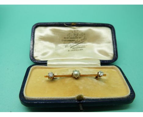 A Victorian brooch set with a pearl and two diamonds, with original box. 