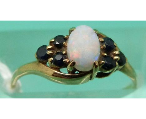 A 9ct gold ring set with an opal and sapphires (Size L)